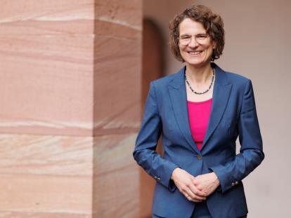 Prof. Dr. Christiane Tietz, Kirchenpräsidentin der EKHN, lächelt in die Kamera. Sie trägt einen blauen Blazer über einem pinkfarbenen Oberteil.